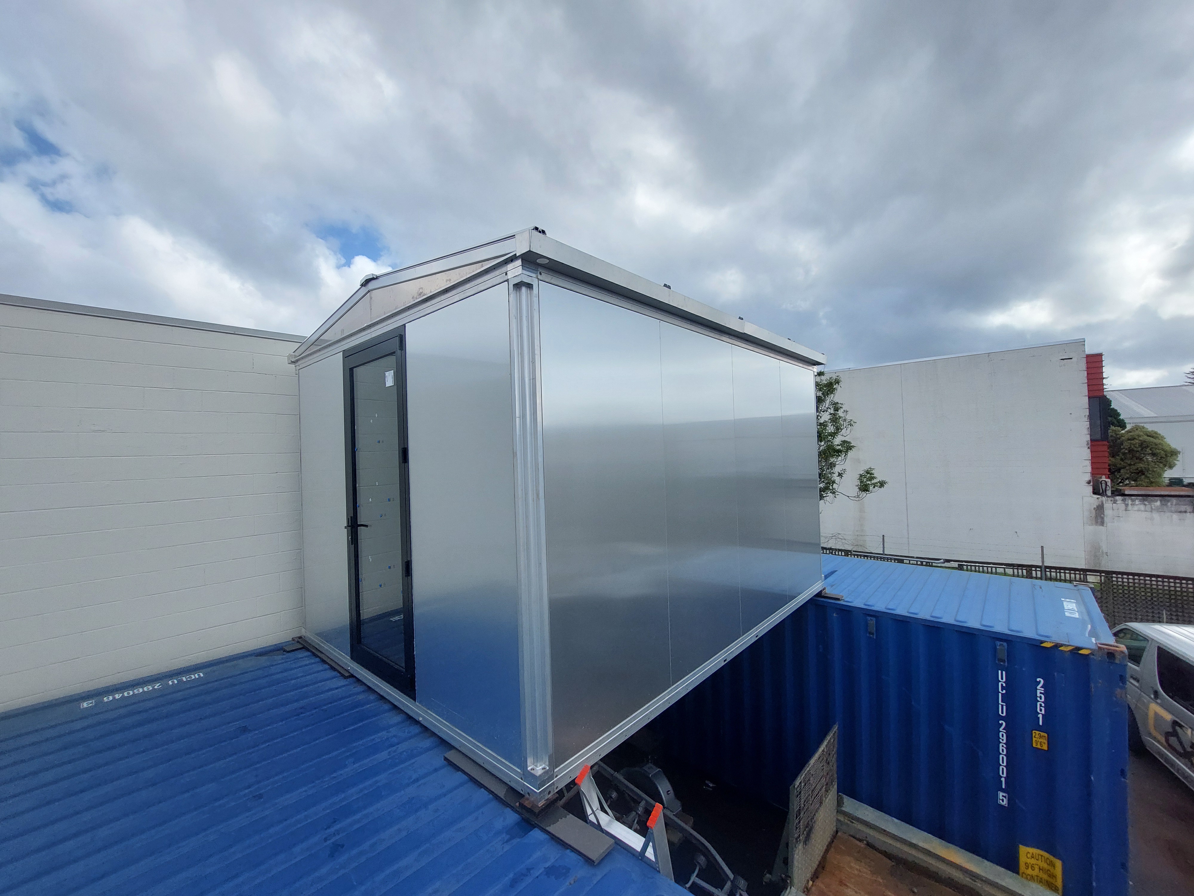Gable module suspended between shipping containers — cyclone test, August 2024